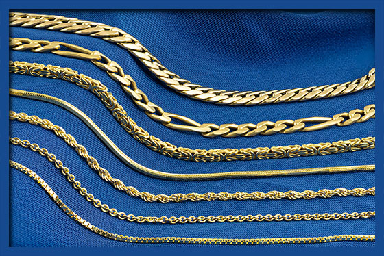 A group of yellow gold chains on a blue background