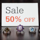 Sale 50 percent off sign with 5 rings in front of it