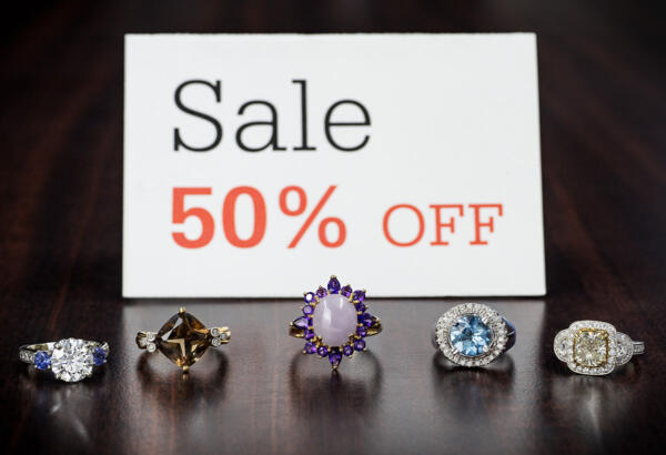 Sale 50 percent off sign with 5 rings in front of it