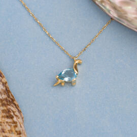 Blue Topaz Dinosaur Pendant in 14k Yellow Gold on blue background